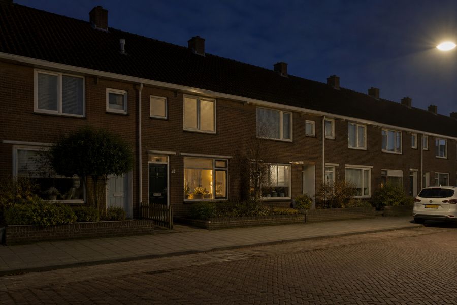 Rijtjeshuis ’s avonds zonder zonnepanelen op het dak: batterijwaarde hangt dan van prijsverschil af.